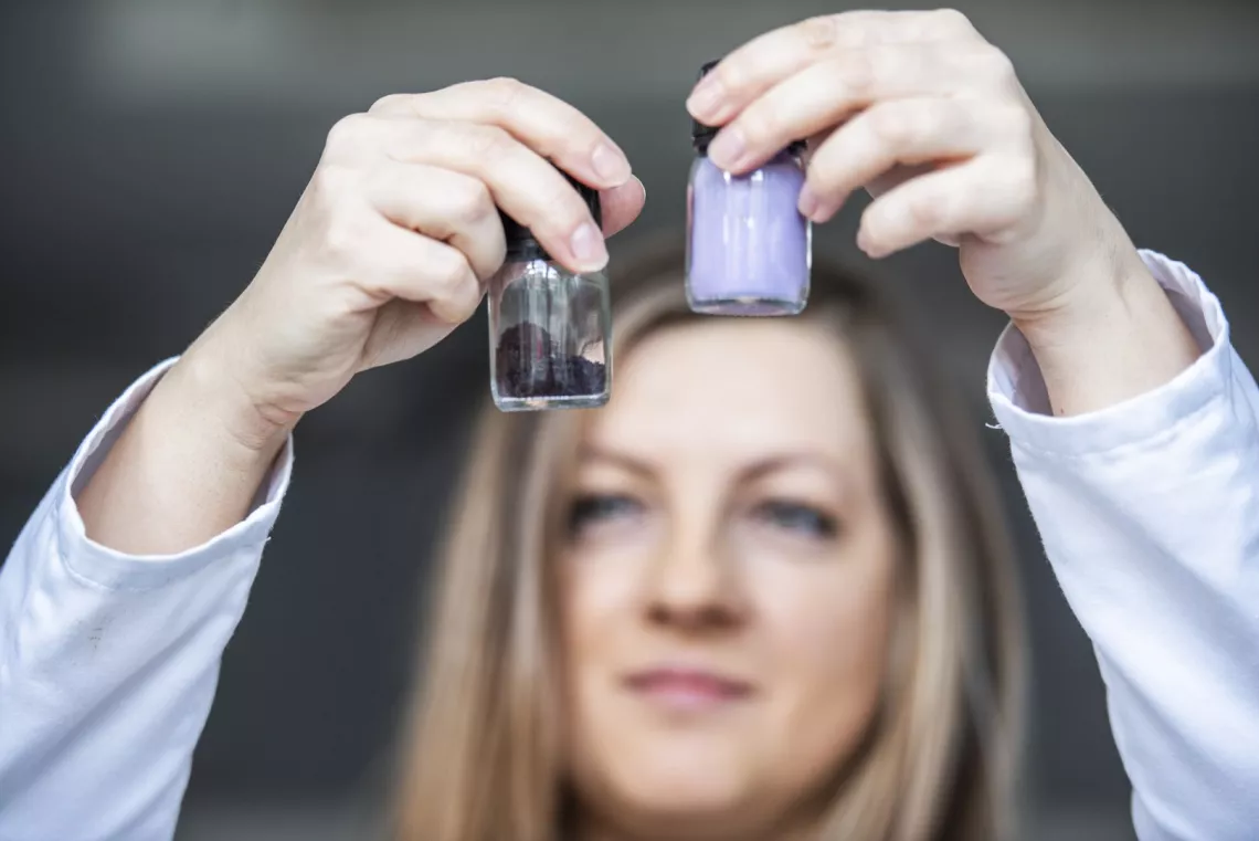 Badaczka trzyma w dłoniach ekstrakt i bioaktywny preparat otrzymane z produktów ubocznych z owoców jagodowych