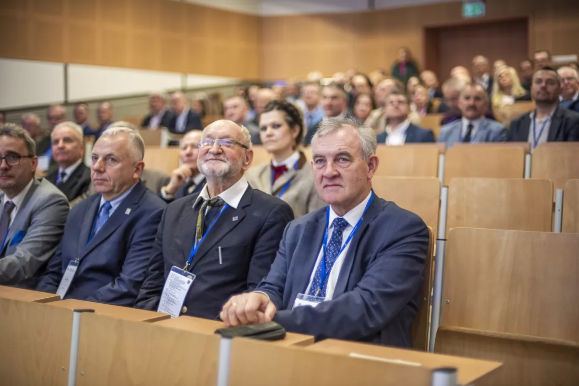 Osoby elegancko ubrane siedzące w audytorium