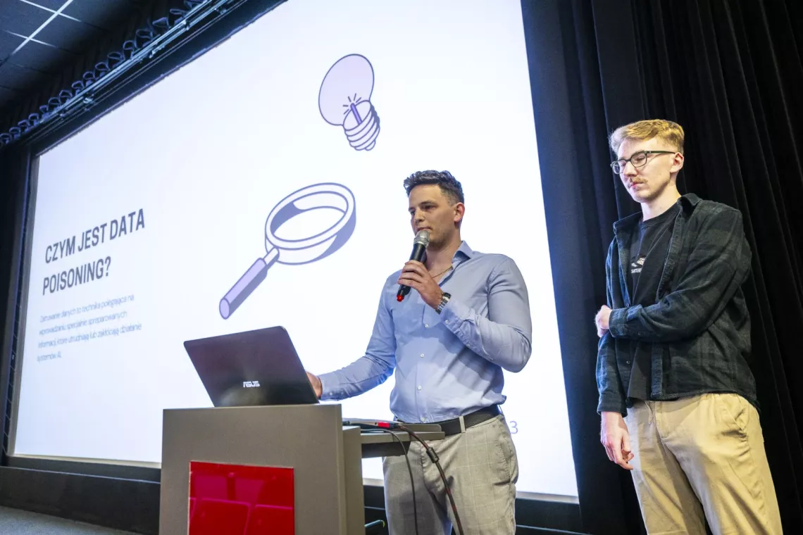 Prezentacja projektu pzrez dwóch studentów, w tle ekran wyświetlający slajdy