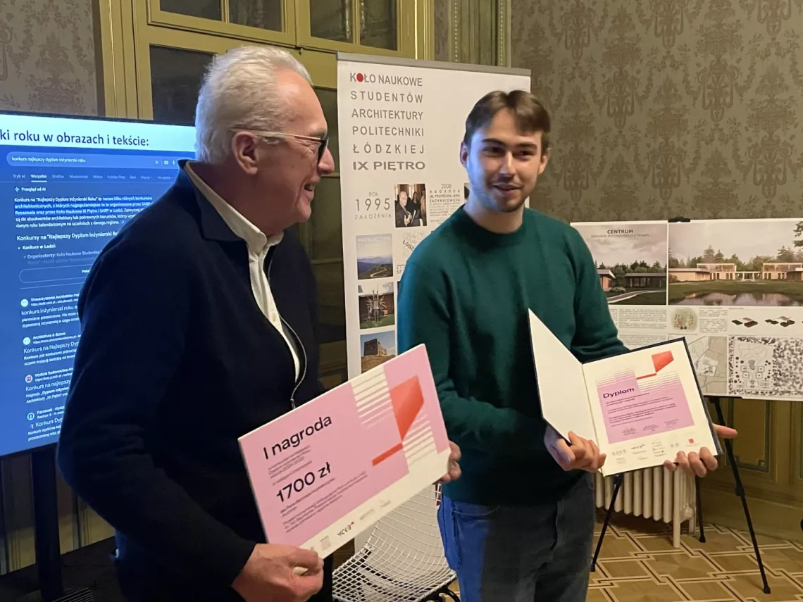 Młody student z dyplomem w ręku, obok mężczyzna w okularch w ciemnym swetrze z symbolicznym czekiem w ręku