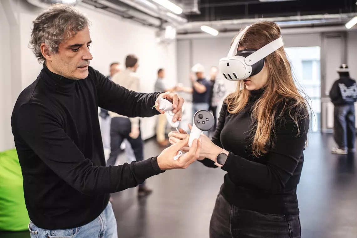 Mężczyzna wspólpracuje z kobietą mającą na oczach gogle VR