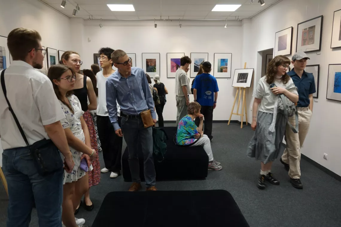 Osoby oglądają prace na wernisażu wystawy