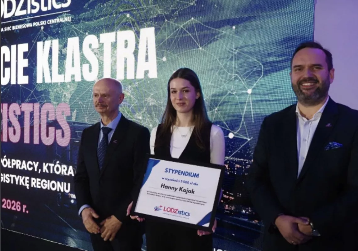 Studentka z dyplomem w ręku stoi między elegancko ubranymi mężczyznami