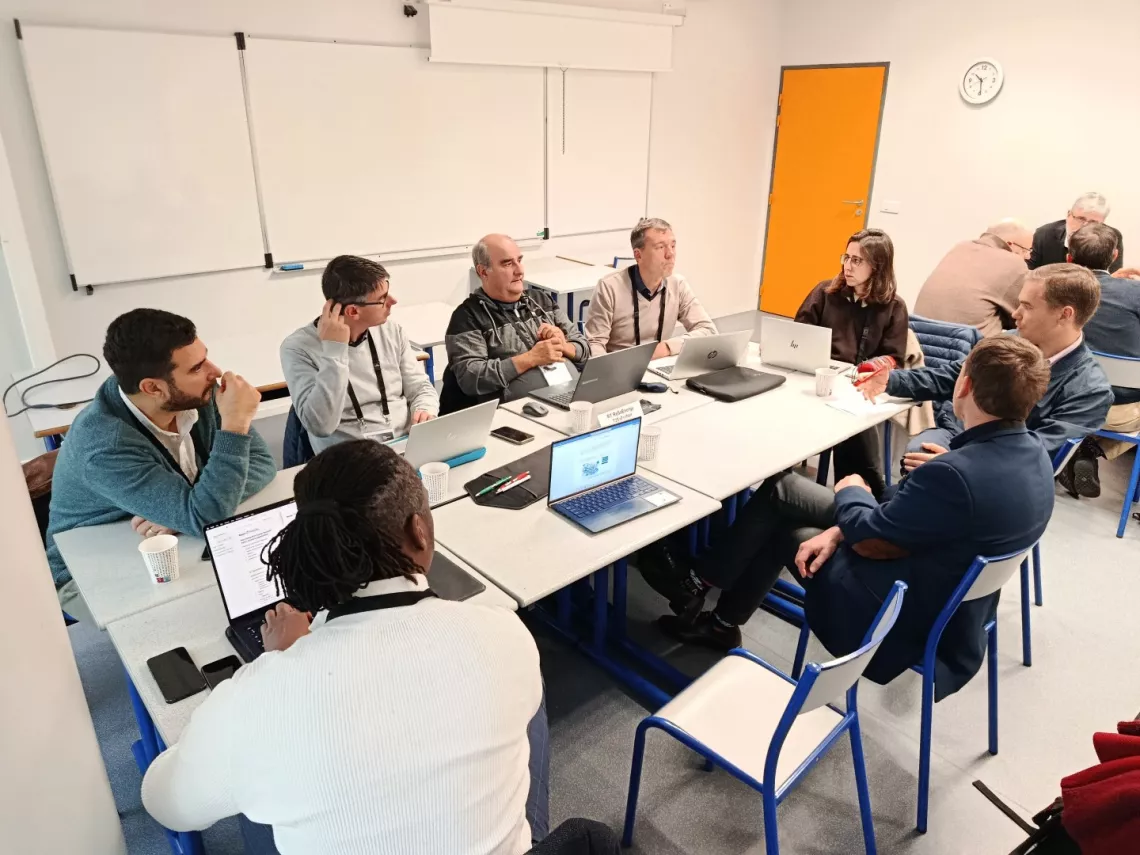 Praca w grupie w czasie spotkania ECIU Research Labs. Kilka osób siedzi przy stole, mając otwrte przed sobą laptopy.