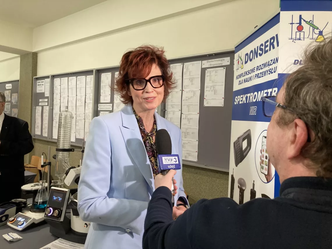 Elegancko ubrana kobieta udziela wywiadu telewizyjnego