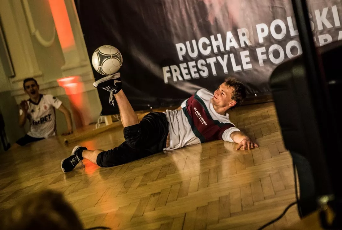 Młody mężczyzna prezentuje swoje umiejetności w freestyle footbol, który też jest jego pasją