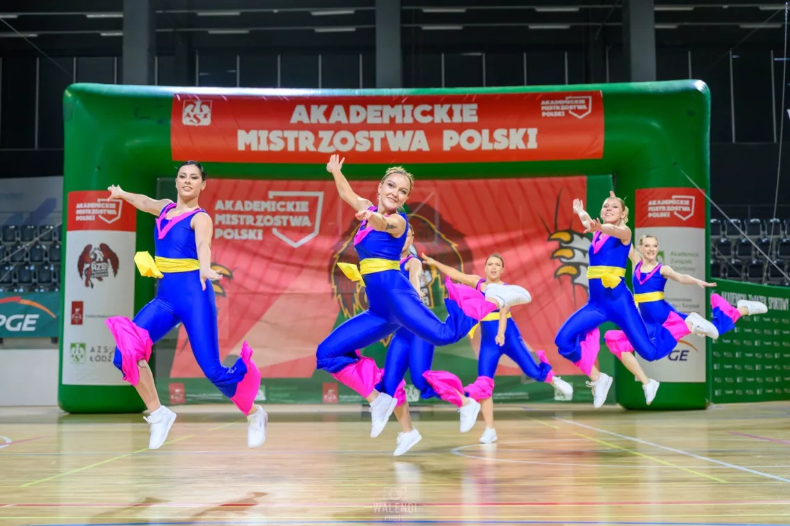 Kilka osób wykonuje układ w aerobiku sportowym