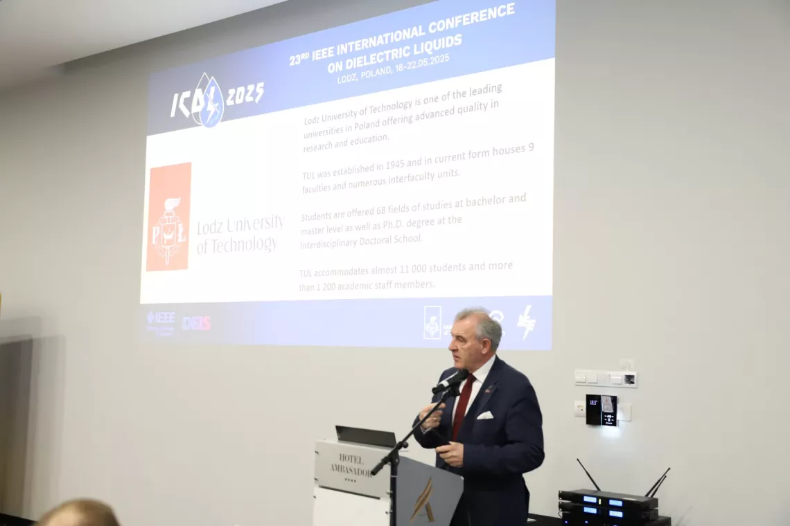 Mężczyzna przy pulpicie przemawiający do mikrofonu