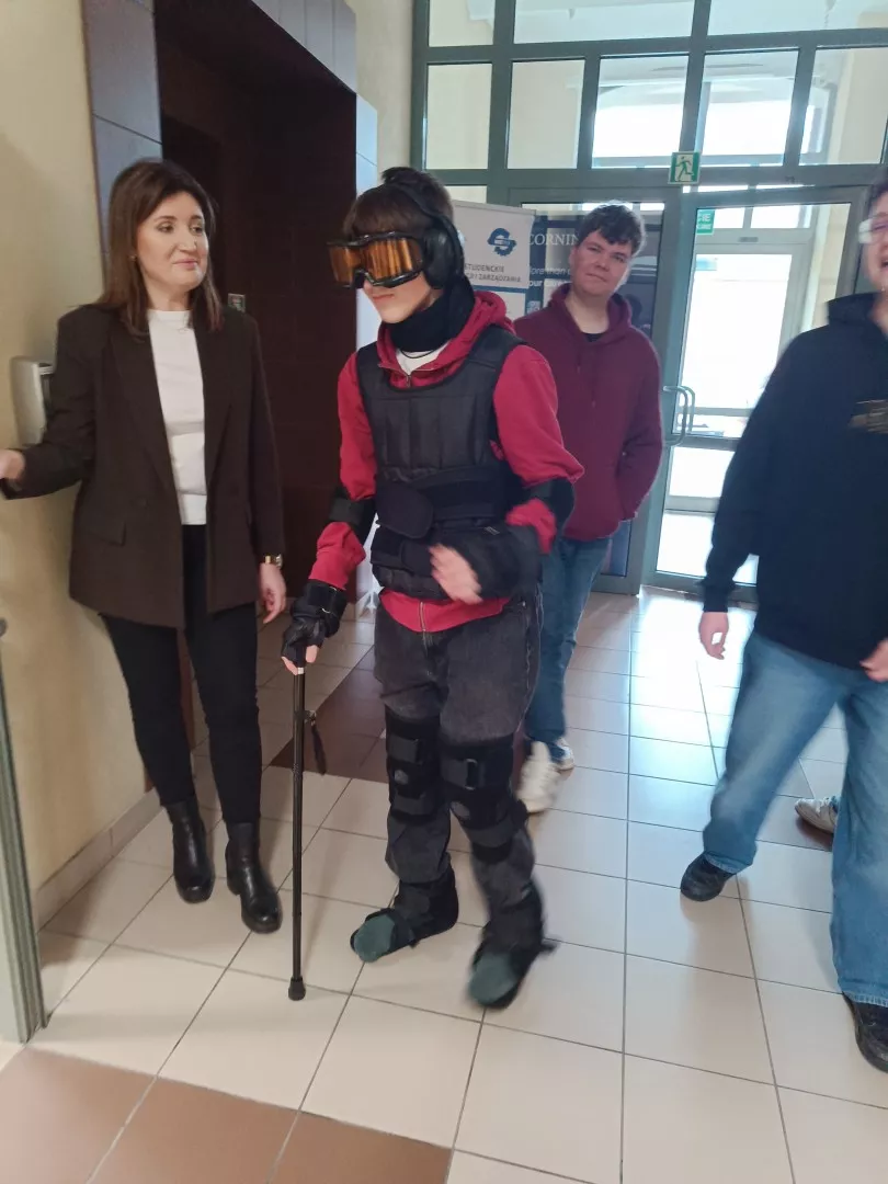 Dziewczyna w goglach VR i ubraniu symulującym fizyczna ułomność