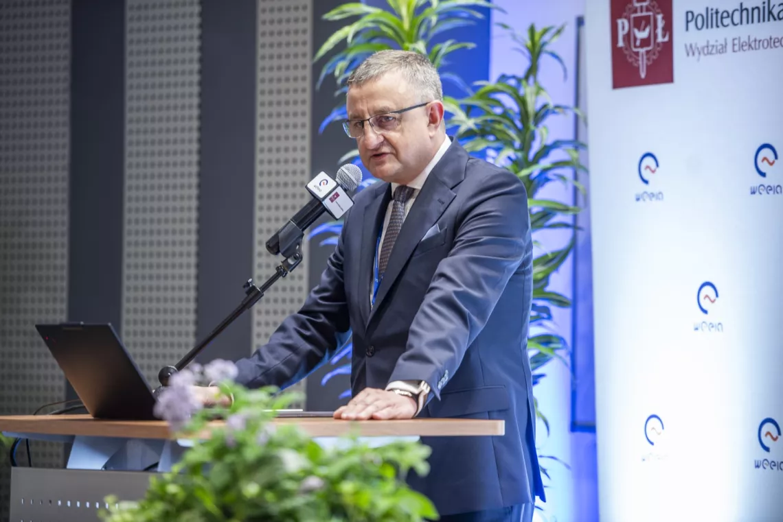 Mężczyzna przy pulpicie przemawiający do mikrofonu