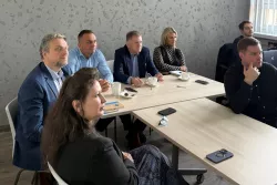 Uczestnicy siedzą w sali seminaryjnej w czasie prezentacji symulacyjnej gry dezcyzyjnej