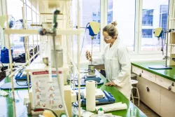 Koordynatorka projektu, naukowczyni w okularch ochronnych i białym fartuchu, w laboratorium biotechnologicznym