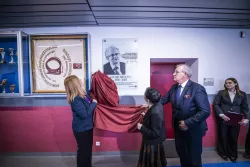 Odsłonięcie tablicy pamiątkowej pzrez dwie kobiety i mężczyznę