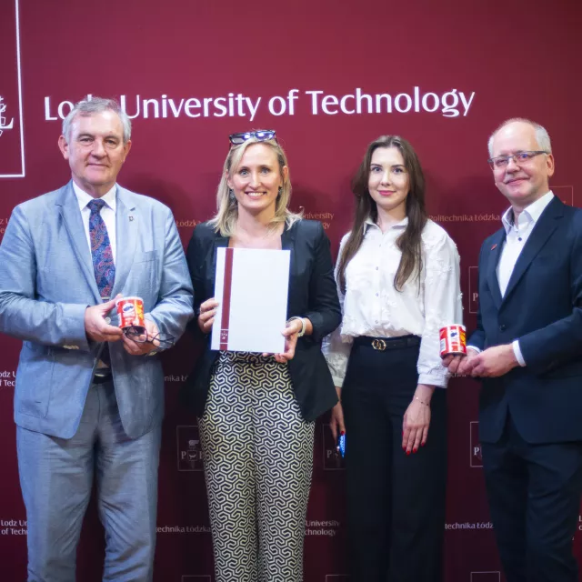 dwóch mężczyzn i dwie kobiety (w środku) stoją na tle baneru z napisem Politechnika Łódzka