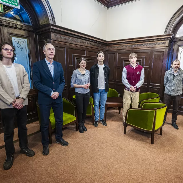 Kilkoro osób stojących w holu rektoratu