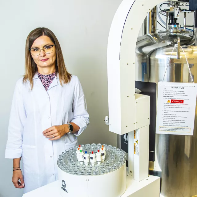 Chemiczka stoi przy aparaturze badawczej