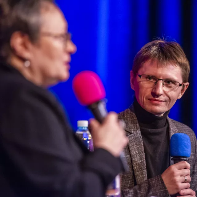 Kobieta i mężczyzna z mikrofonami w ręku prowadzą rozmowę