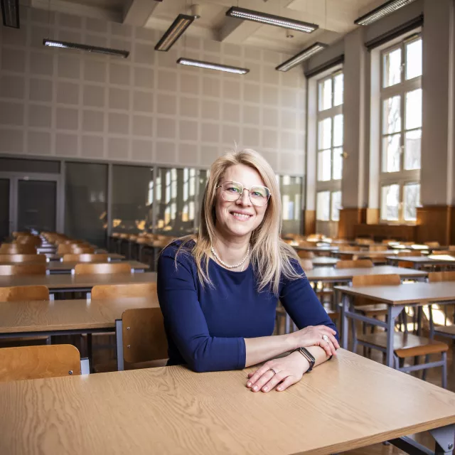 Kobieta siedzi za stołem w sali seminaryjnej