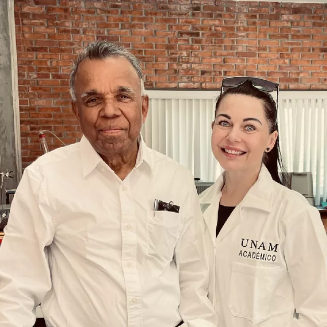 Mężczyzna i kobieta  w białych fartuchach, stoją w laboratorium na tle ceglanej ściany 