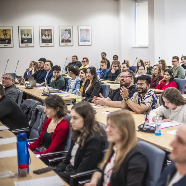Doktoranci z różnych krajów na siedzą w sali konferencyjnej