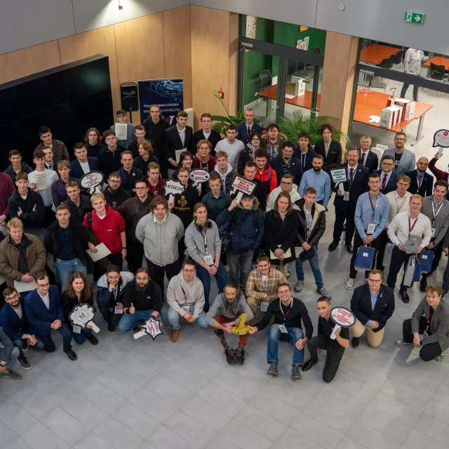 Bardzo duża grupa studentów stoi w holu