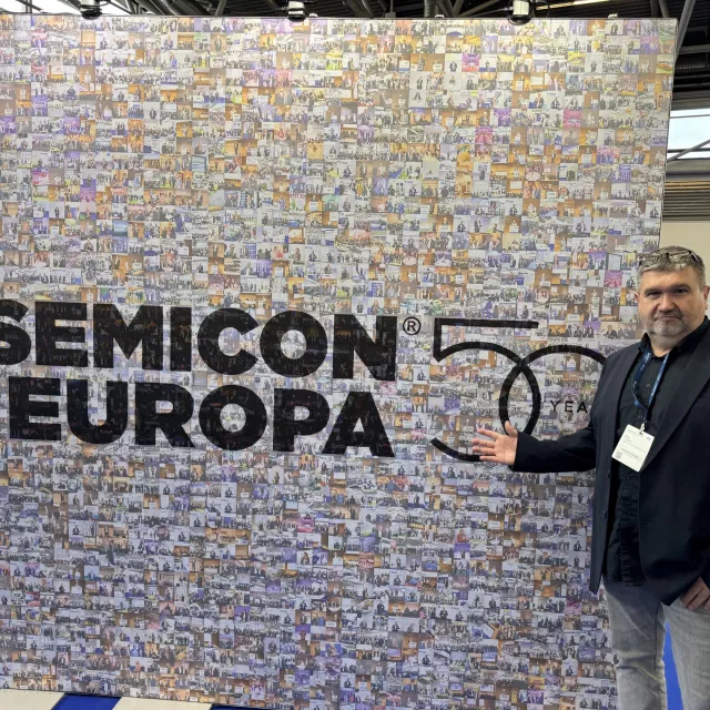 Dr inż. Jacek Podgórski na tle wizualizacji ilustrujacej rozwój branzy połprzewodników